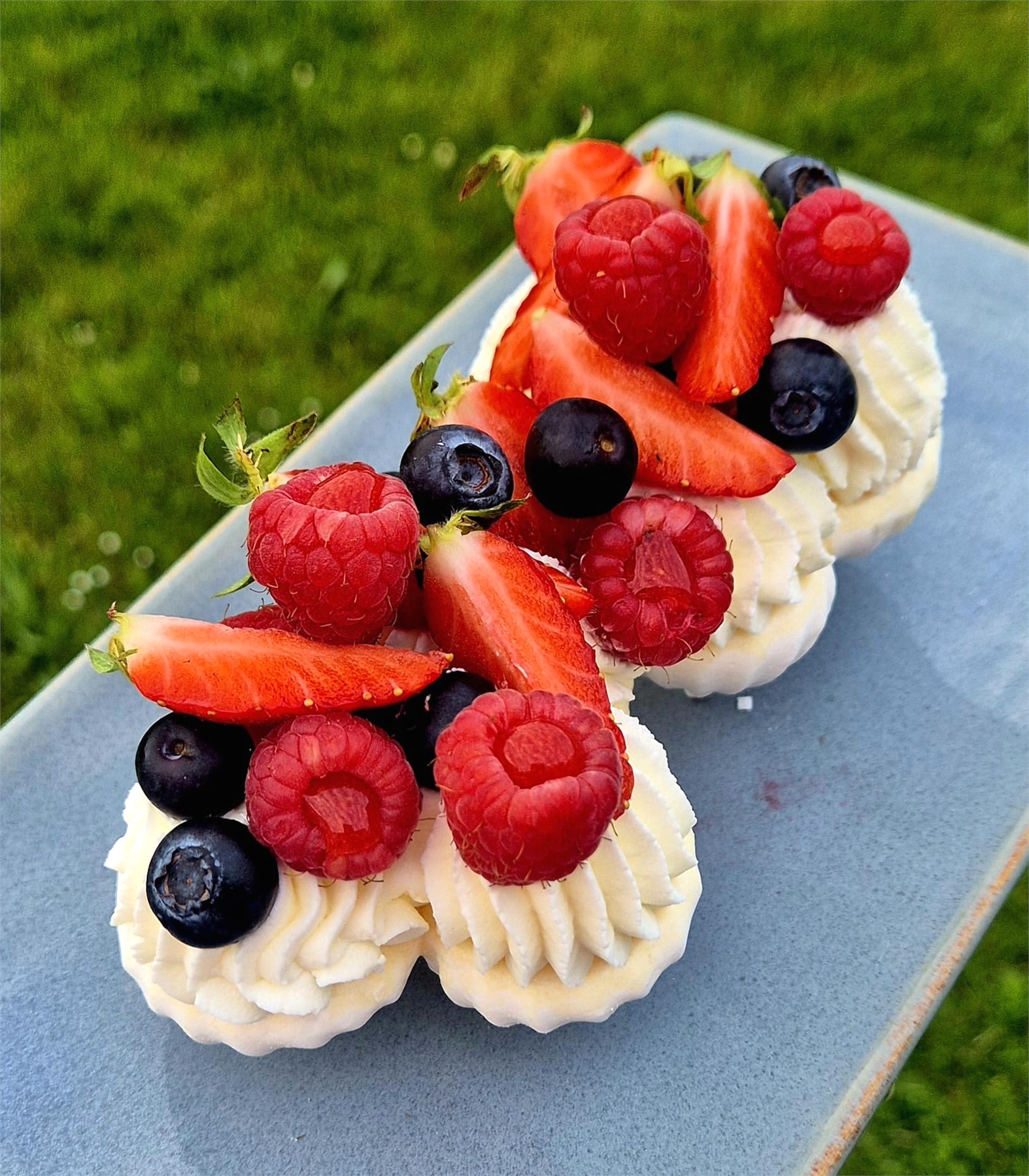 Pavlova aux fruits rouges sur assiette bleue