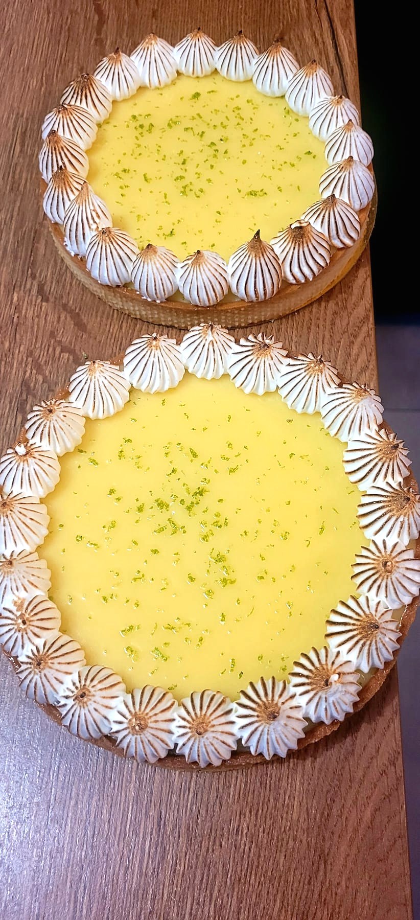 Deux tartes citron meringuées sur table en bois